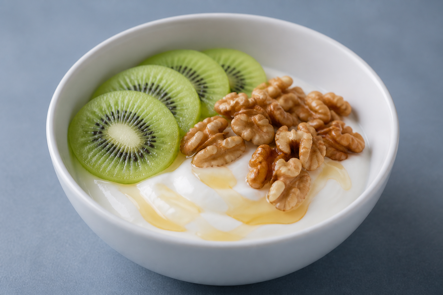 Bol de fromage blanc avec cerneaux de noix, tranches de kiwi et filet de miel — petit-déjeuner équilibré faible index glycémique